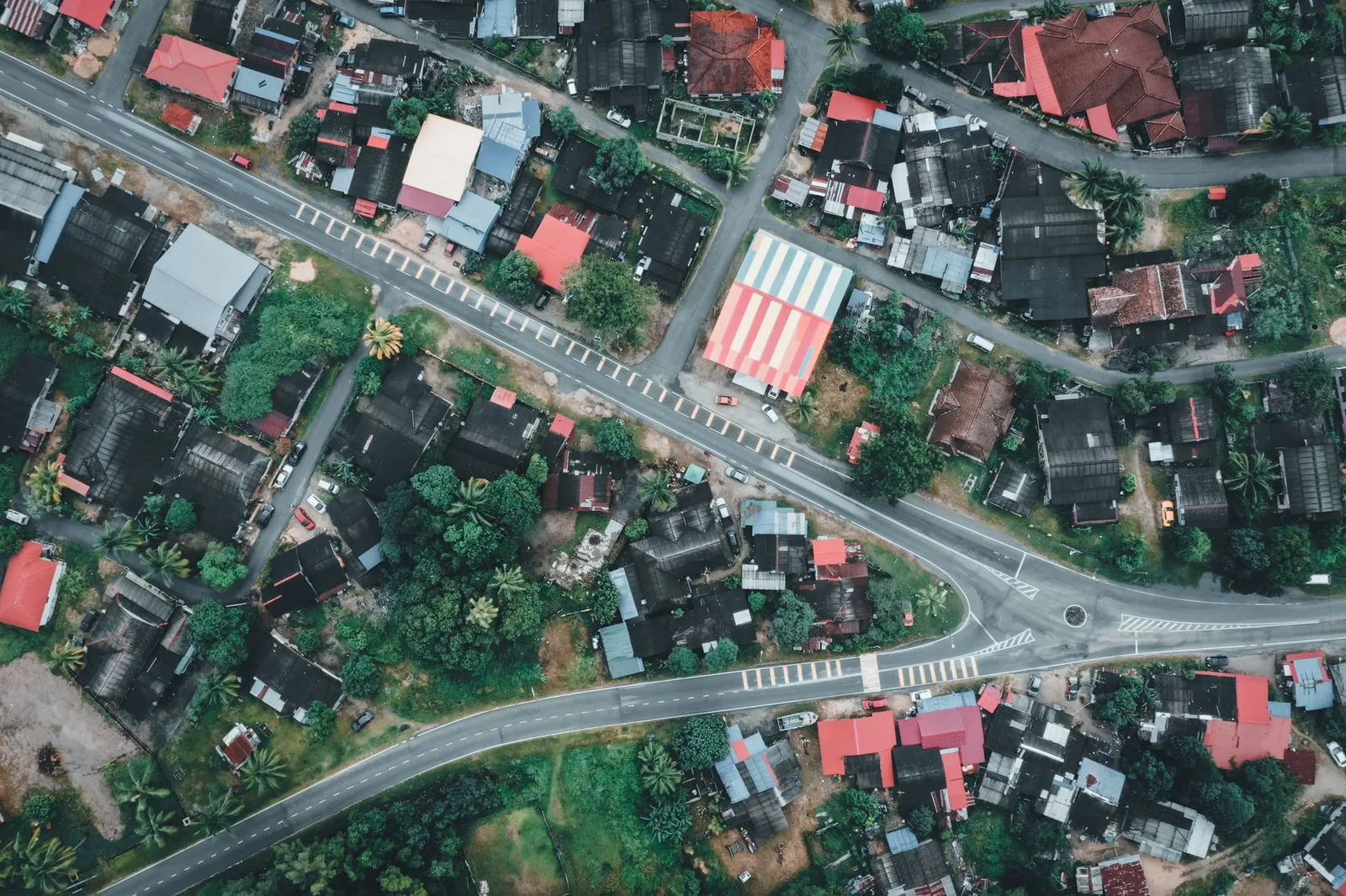 High-angle shot of residential architecture in Chukai, Terengganu, Malaysia, showcasing vibrant rooftops and lush greenery.