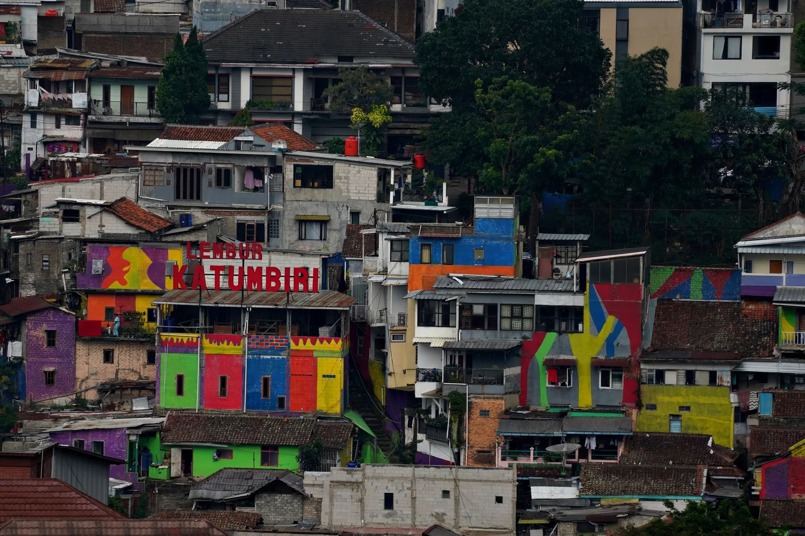 Vibrant painted buildings in a densely packed Indonesian neighborhood.
