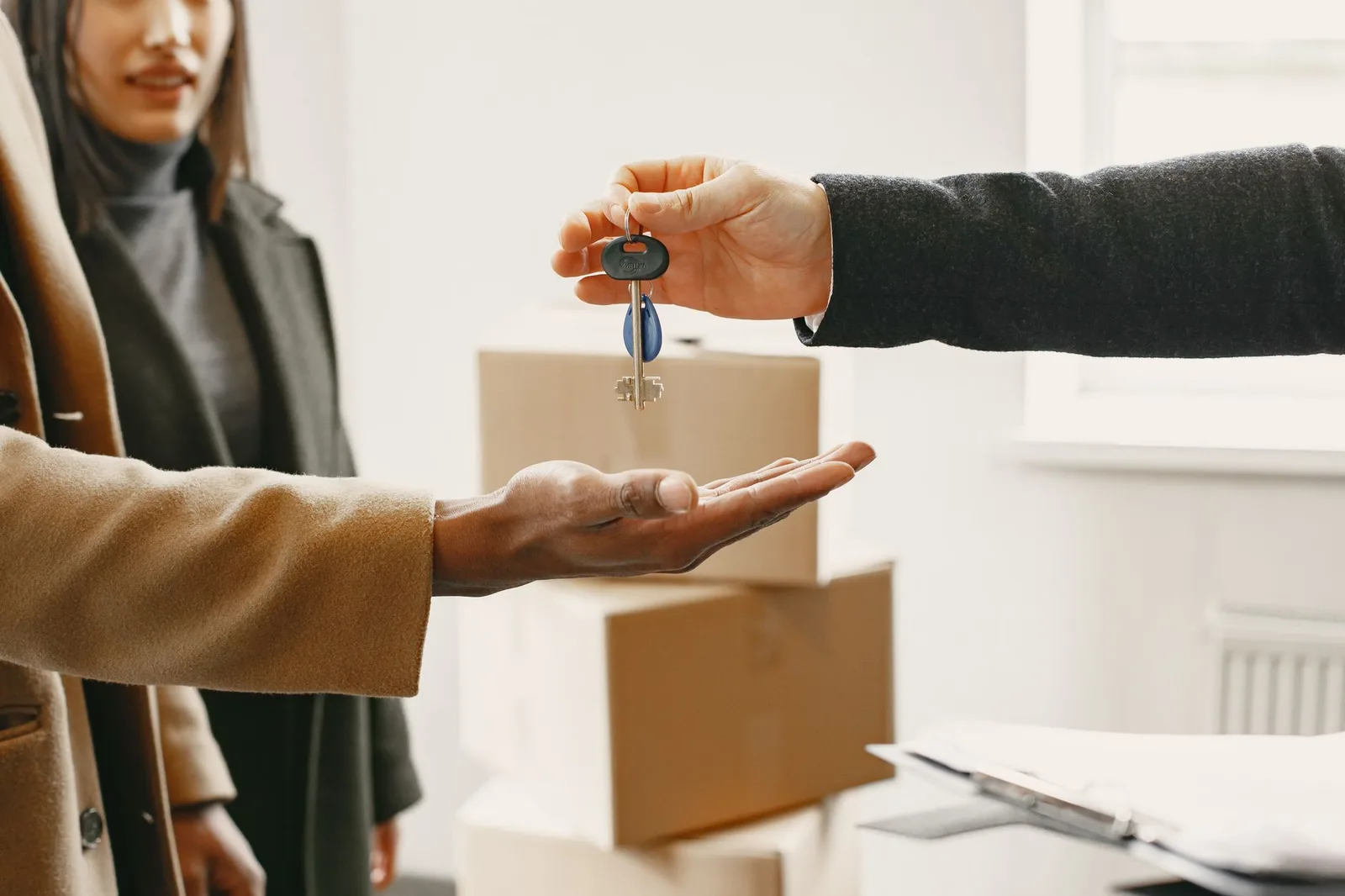 A new homeowner receives keys inside their new home, symbolizing a fresh start.