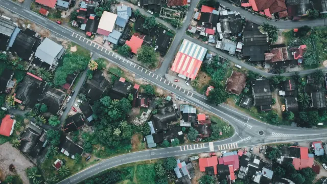 High-angle shot of residential architecture in Chukai, Terengganu, Malaysia, showcasing vibrant rooftops and lush greenery.