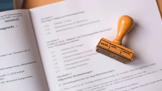 Close-up of a legal document with a wooden stamp placed on top, highlighting verification.