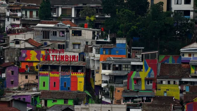 Vibrant painted buildings in a densely packed Indonesian neighborhood.