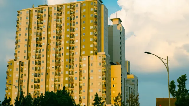 High-rise apartment building in Bandung, Indonesia, captured at sunset with dramatic clouds.