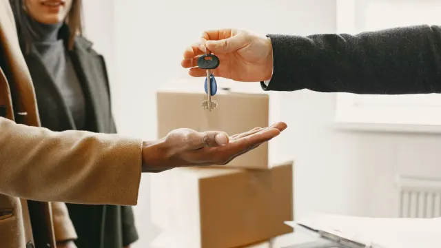 A new homeowner receives keys inside their new home, symbolizing a fresh start.