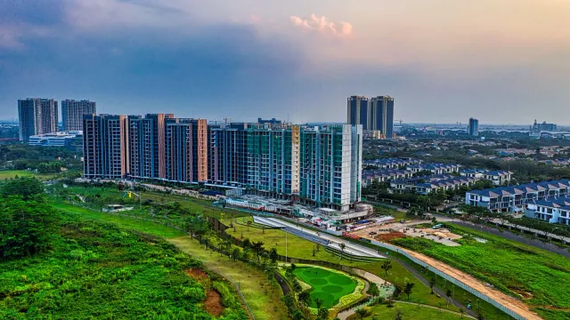 Drone shot capturing modern apartment buildings and green spaces in Banten, Indonesia at sunset.